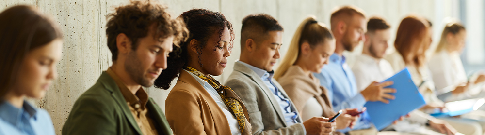 Group of applicants sit in a waiting area as they prepare for their interview.