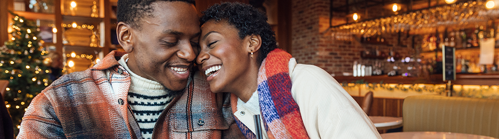 A couple enjoys drinks in a cafe around the holidays.