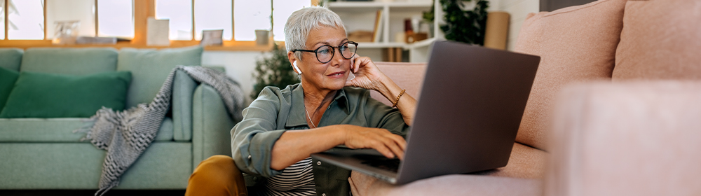 Woman reviews email on her laptop in her living room.