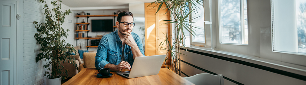 Man looks at his computer deep in thought.