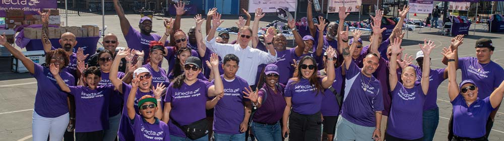 Kinecta employees cheer during a backpack distribution event.