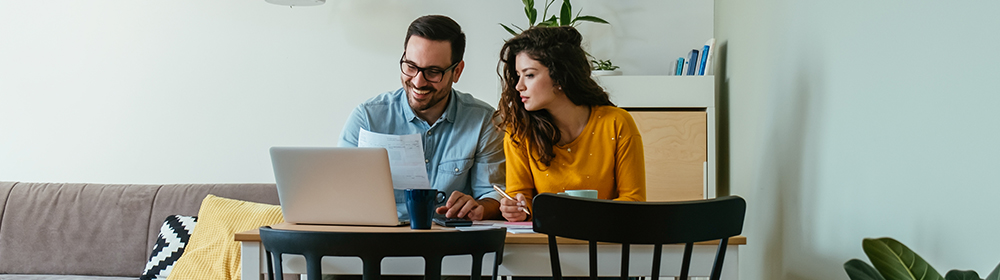 A couple looking over bills in their living room.